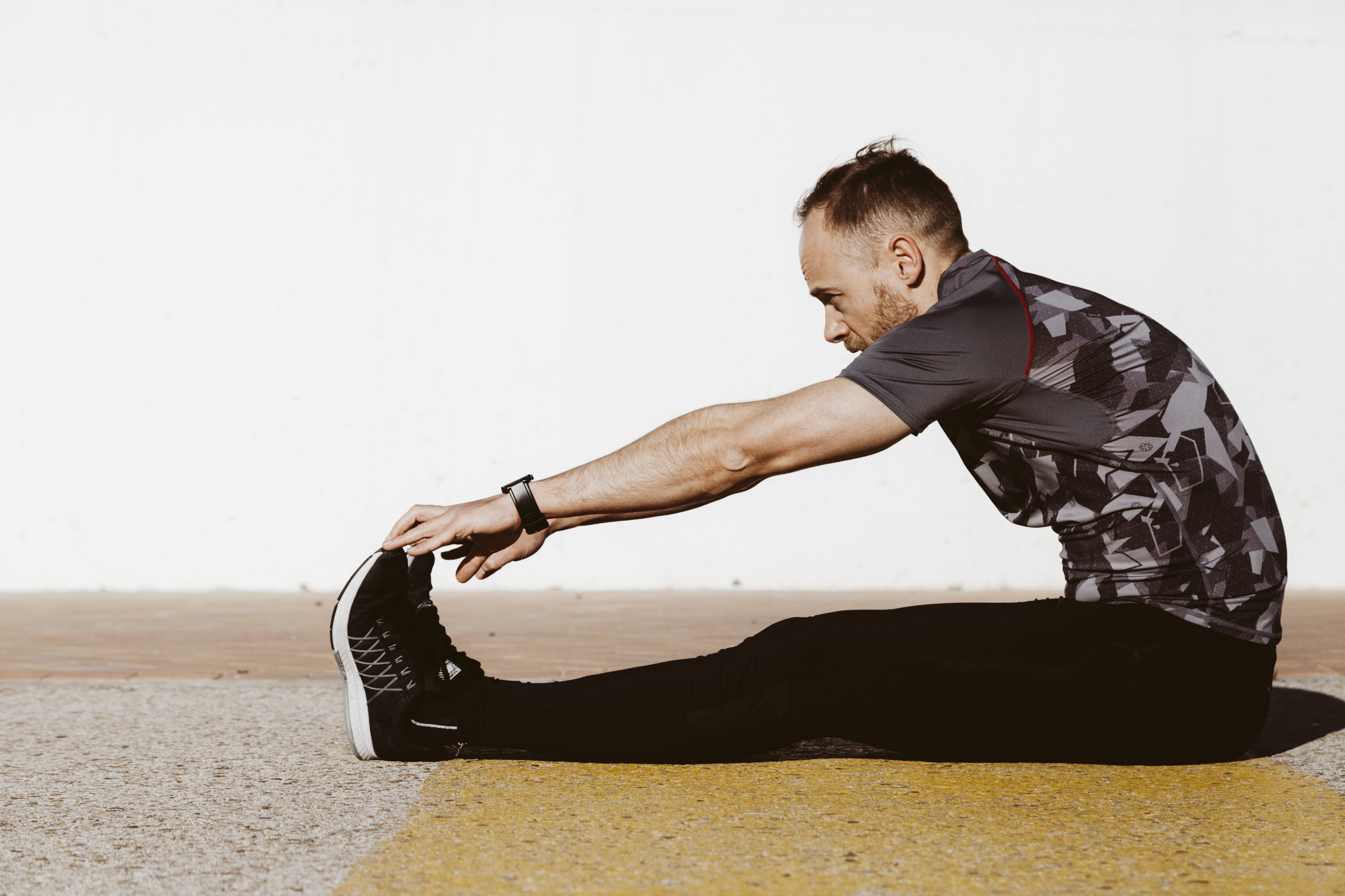 middle-aged-man-sports-uniform-stretching-floor